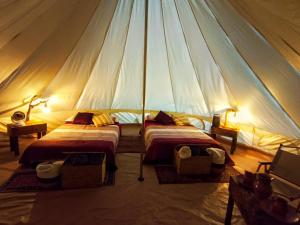 a tent with two beds in a room at Chantli Nawi Glamping & Temazcal in Ixtafiayuca