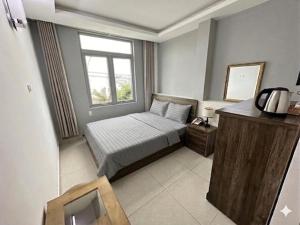 a small bedroom with a bed and a window at Thanh 57 TKH Hotel - Giá mềm ngay bên chợ Đà Lạt in Da Lat