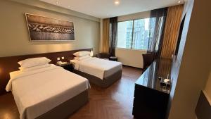 ein Hotelzimmer mit zwei Betten und einem Fenster in der Unterkunft Hotel Royal Singapore in Singapur + 28 Fotos