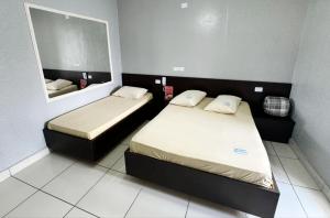 a small bedroom with two beds and a mirror at Hotel Divisa poá in Poá