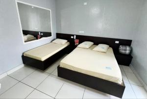 a small room with two beds and a mirror at Hotel Divisa poá in Poá