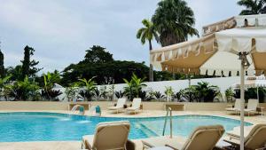 a swimming pool with chaise lounge chairs next to a resort at Bella Vista Coral Sea Views in Port Douglas +4 photos