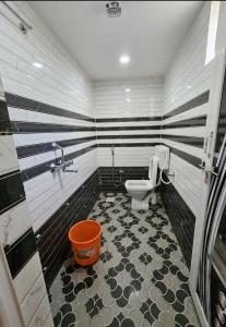 a bathroom with a toilet with black and white stripes at Villa Retreat Cottages Ramnagar in Londa