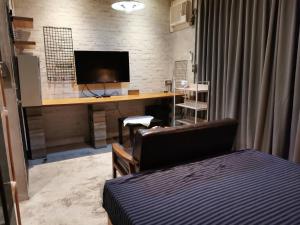 a bedroom with a bed and a desk with a television at 基隆正榮003 in Pa-ch'ih-men
