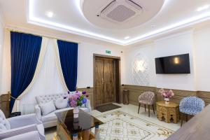 a living room with a couch and a tv at Boutique Hotel IMONA in Samarkand