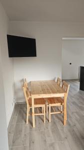 a wooden table with two chairs and a flat screen tv at Vila Jesenice in Lipová +25 photos