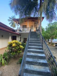 a staircase leading up to a house with a palm tree at New Vilard in Tissamaharama