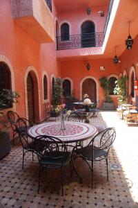 a patio with a table and chairs in a courtyard at Riad Afriquia Garden in Marrakesh