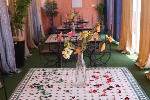 a vase filled with flowers sitting on a table at Riad Afriquia Garden in Marrakesh