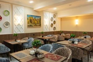 a restaurant with tables and chairs in a room at Boutique Hotel IMONA in Samarkand