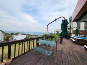 a balcony with a bench and an umbrella at Haepung Stay in Yŏnamp'o