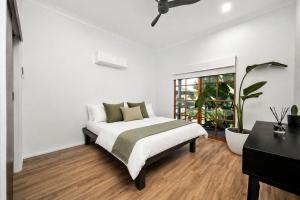 a white bedroom with a bed and a desk at Eune House in Broke