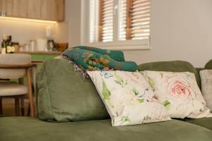 two pillows on the back of a green couch at House Olive Tree in Bijela