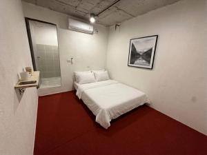 ein kleines Zimmer mit einem Bett und einem Spiegel in der Unterkunft KINBOSHI Inn in Bangkok