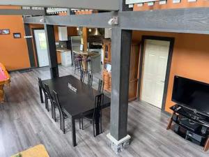 a black table and chairs in a room with a tv at GROWL Lodge - Hot Tub & Mountain Views! in Golden