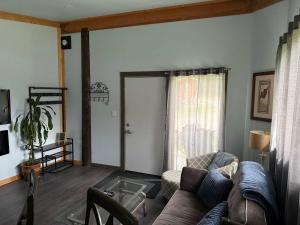 a living room with a couch and a window at Pine Marten Wilderness Cabin - Hot Tub & Mountain Views in Golden