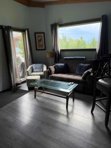 a living room with a couch and a coffee table at Pine Marten Wilderness Cabin - Hot Tub & Mountain Views in Golden