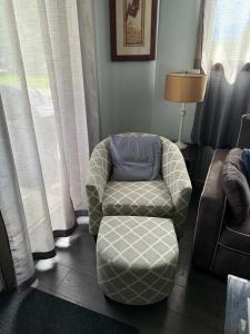 a chair and a ottoman in a living room at Pine Marten Wilderness Cabin - Hot Tub & Mountain Views in Golden +18 photos