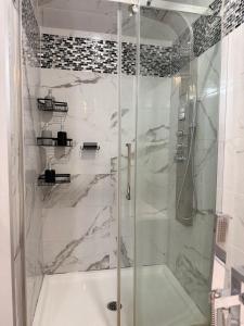 a shower with a glass door in a bathroom at Manoir Chris in Saint-Augustin-de-Desmaures +85 photos