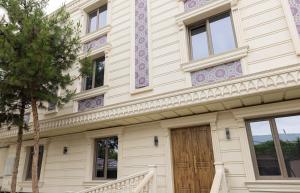 a building with a wooden door and a tree at Boutique Hotel IMONA in Samarkand