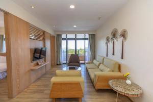 a living room with a couch and a tv at Sea Passion Hotel in Koror