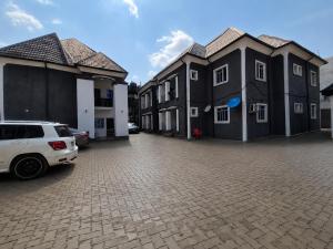 a row of houses with cars parked in a parking lot at EIMACK APARTMENT Service in Asaba