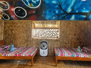 a room with two beds and a wall with a painting at Bamboo Nest Beachfront in Puerto Princesa City +85 photos