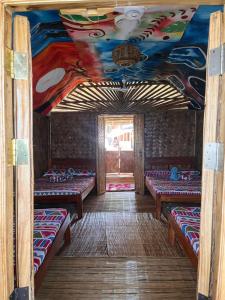a room with four beds and a painting on the ceiling at Bamboo Nest Beachfront in Puerto Princesa City