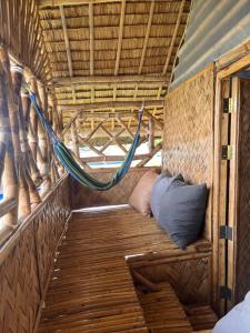 a hammock in the back of a tent at Bamboo Nest Beachfront in Puerto Princesa City