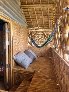 a bed in the inside of a tent with a hammock at Bamboo Nest Beachfront in Puerto Princesa City