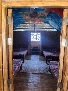 a room with three beds and a window at Bamboo Nest Beachfront in Puerto Princesa City