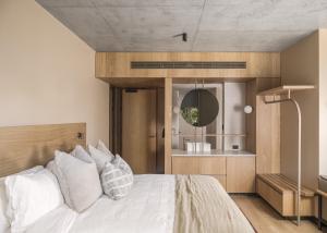 a bedroom with a white bed and a mirror at Hotel Marvell Byron Bay in Byron Bay