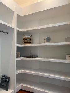 a white closet with white shelves in a room at Juntas Del Lago in Apulo