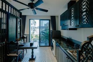 a kitchen with a table and a ceiling fan at Dérive Boutique Villa & Apartment Da Nang in Danang