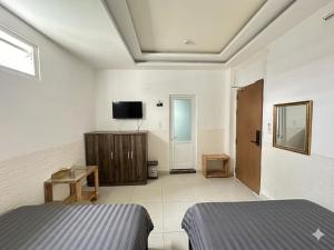 a bedroom with two beds and a flat screen tv at Thanh 57 TKH Hotel - Giá mềm ngay bên chợ Đà Lạt in Da Lat