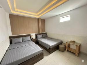 a hotel room with two beds and a window at Thanh 57 TKH Hotel - Giá mềm ngay bên chợ Đà Lạt in Da Lat