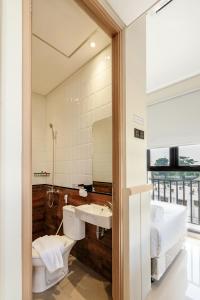 a bathroom with a sink and a bed and a mirror at Rucio Kostel Semarang in Jatingaleh +30 photos