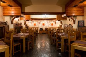 a dining room with wooden tables and chairs at Pensiunea Casa Georgia in Comăneşti