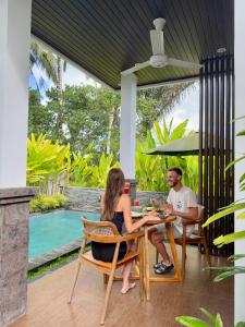 a man and woman sitting at a table on a patio at Arvanya Villa Ubud in Tegalalang +52 photos