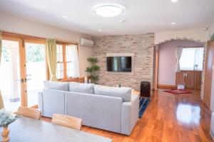 a living room with a couch and a tv at Star Peak Villa 黒川 in Minamioguni