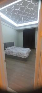 a bedroom with a bed in a room with a ceiling at Hakim Karim Apartments in Khujand