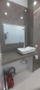 a bathroom with a sink and a mirror at Hakim Karim Apartments in Khujand