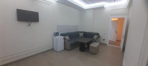 a living room with a couch and a tv on a wall at Hakim Karim Apartments in Khujand