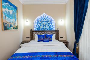 a bedroom with a bed with blue and white at Boutique Hotel IMONA in Samarkand +63 photos