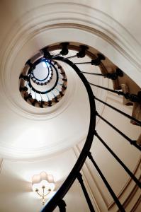 a spiral staircase in a building with a ceiling at Splendid Etoile in Paris