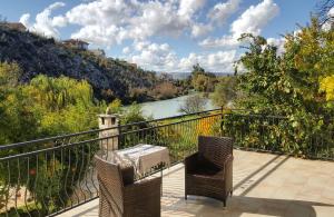 a balcony with a table and chairs and a river at Villa Velagic in Blagaj