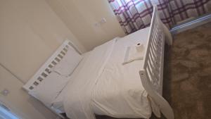 a bedroom with a bed with white sheets and pillows at Hilcot House in Kirby Muxloe +42 photos