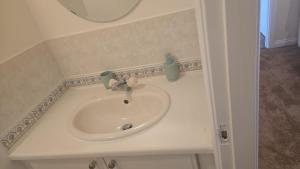 a white sink in a bathroom with a mirror at Hilcot House in Kirby Muxloe