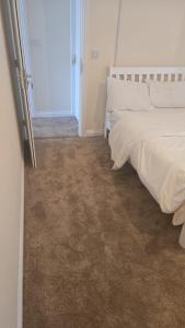 a bedroom with two beds and an open door at Hilcot House in Kirby Muxloe
