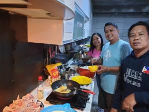 a group of people in a kitchen preparing food at popcorn hostel haeundae in Ch'ŏngsap'o